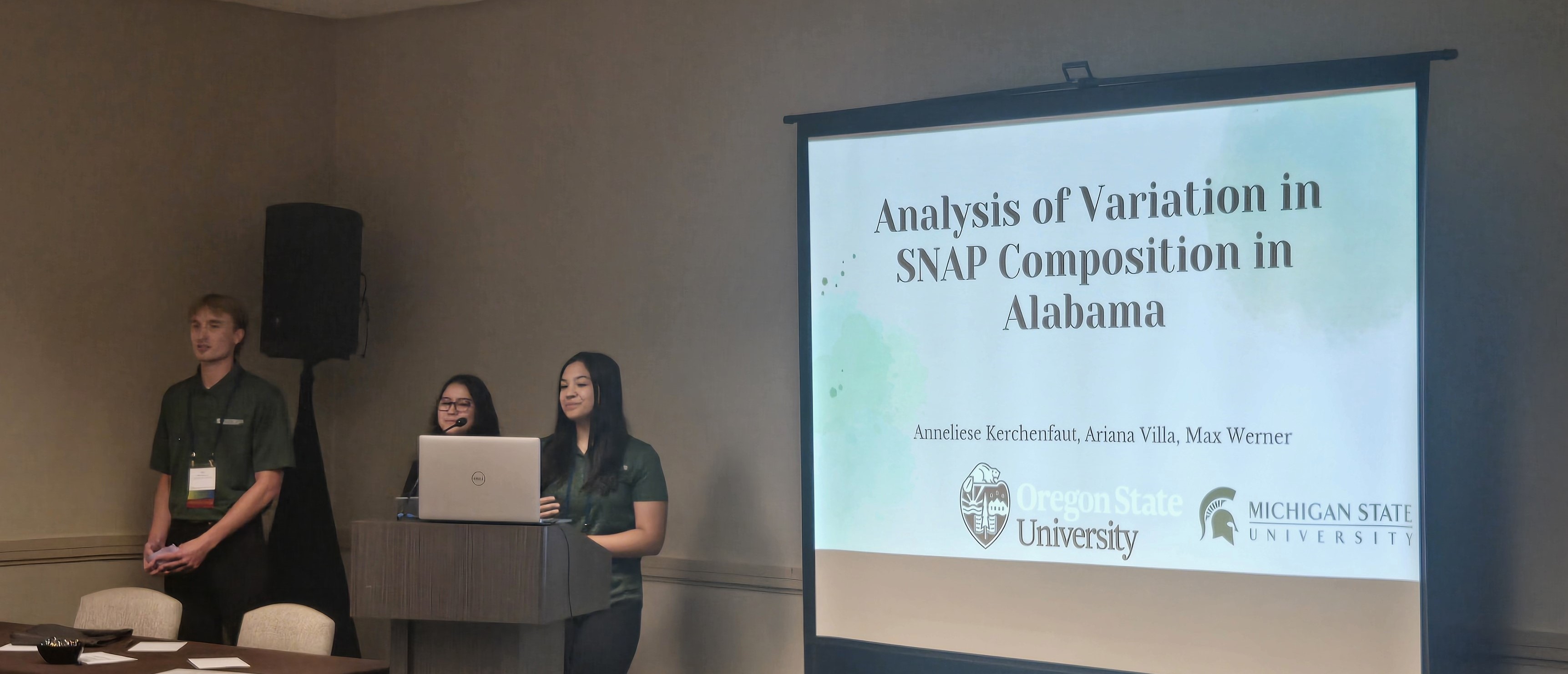 Students presenting at conference in front of PowerPoint